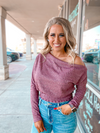 Ribbed off shoulder knit top with long sleeves and smocked waist in mauve.